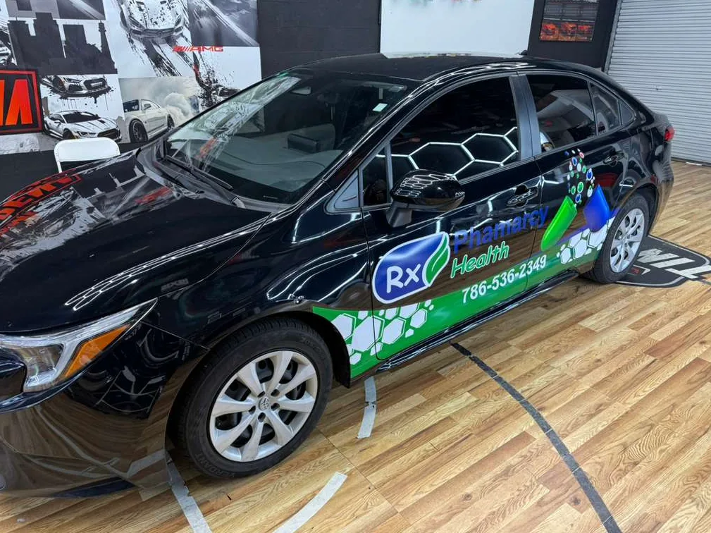 Black branded service car with carbon window tint inside a professional tint shop